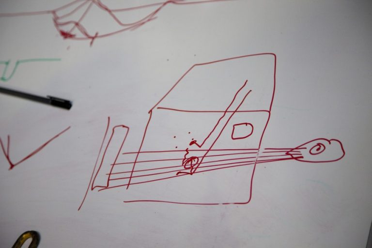 Whiteboard sketch of a tool reaching a dent