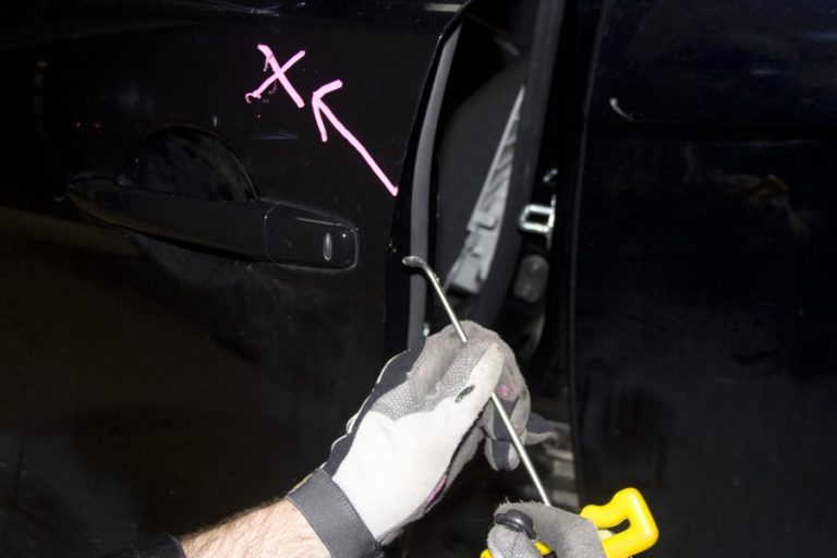 A marked dent and a hand rod at a door